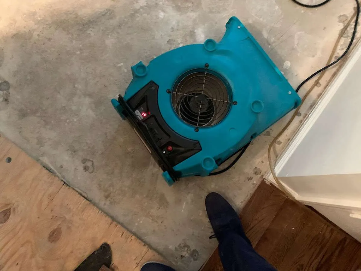Air mover drying subfloor during Commercial Water Damage Restoration in Exeter